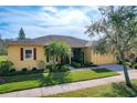 This single story home features mature landscaping, an attached two car garage, and sidewalk at 127 Terra Vista Ln, Kissimmee, FL 34759