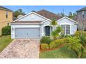 One-story home with gray siding, brick driveway and landscaping at 1404 Lexington Avenue, Davenport, FL 33837