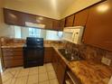 Condo kitchen with brown cabinets, tile counters, and appliances at 2024 Trinidad Ct, Kissimmee, FL 34741