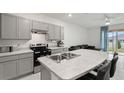Modern kitchen featuring stainless steel appliances, gray cabinets, and an island at 2352 Tay Wes Dr, St Cloud, FL 34771