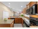 Kitchen features oak cabinets, black appliances, and an island at 2542 Bobby Lee Ln, St Cloud, FL 34772