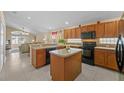 Spacious kitchen with oak cabinets, island, and black appliances at 2542 Bobby Lee Ln, St Cloud, FL 34772