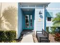 Front entrance with teal door and a black bench, offering curb appeal at 3065 Caribbean Soul Dr, Kissimmee, FL 34747