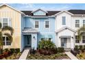 Three-unit townhome building, featuring pastel-colored exteriors and landscaping at 3065 Caribbean Soul Dr, Kissimmee, FL 34747