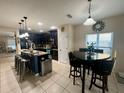 Modern kitchen with dark cabinets and an island with seating at 4702 Greycliff Prairie Dr, Kissimmee, FL 34758