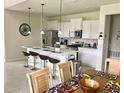 Bright kitchen with white cabinets, an island, and stainless steel appliances at 5465 Misty Oak Cir, Davenport, FL 33837