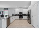Modern kitchen with white cabinets, stainless steel appliances, and gray countertops at 641 Pebble Beach Dr, Davenport, FL 33896