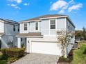 Two-story house with light blue siding, white garage door, and landscaped front yard at 8939 Zurich Ln, Kissimmee, FL 34747