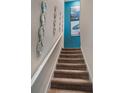 Carpeted stairway with modern wall decor leads to the upper level at 8976 Azalea Sands Ln # 2604, Davenport, FL 33896