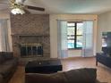 Comfortable living room featuring a brick fireplace and a window view of the outdoor pool at 974 Feather Dr, Deltona, FL 32725
