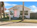 Gray siding house with pink door and mature palm trees at 1001 11Th St, St Cloud, FL 34769