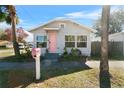 Charming bungalow with pink door and well-manicured lawn at 1001 11Th St, St Cloud, FL 34769