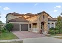 Two-story house with stone accents and a two-car garage at 14657 Winter Stay Dr, Winter Garden, FL 34787