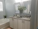 Double vanity bathroom with granite countertops at 180 Daigledog St, St Cloud, FL 34772