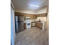 Well-lit kitchen featuring stainless steel refrigerator, range, and ample cabinet space at 1919 Bentley Blvd, Kissimmee, FL 34741