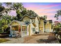 Charming yellow two-story home featuring a welcoming front porch and brick driveway at 2223 Amherst Ave, Orlando, FL 32804