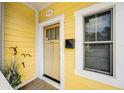 Inviting front door with yellow paint and white trim and 'Aloha Hale Nui' sign at 2223 Amherst Ave, Orlando, FL 32804