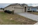 A charming house with a gray exterior, a two-car garage, and a neat front yard at 231 Tarpon Bay Blvd, Haines City, FL 33844