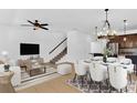 Open-concept living and dining area with modern furnishings, stylish decor, and staircase to upper level at 2617 Amati Dr, Kissimmee, FL 34741