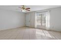 Bright living room featuring tile flooring, ceiling fan, and a large window with natural light at 33 W Country Cove Way, Kissimmee, FL 34743
