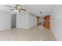 Open concept living area with tile flooring, ceiling fan, and access to kitchen with wood cabinetry at 33 W Country Cove Way, Kissimmee, FL 34743
