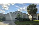 Two-story house with gray exterior, white garage door, and palm trees at 507 Cassia Dr, Davenport, FL 33897