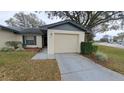 One-story home with attached garage and mature trees at 56 Buck Cir, Haines City, FL 33844