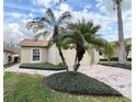 Single-story home with a two-car garage and lush landscaping at 612 Grand Canal Dr, Poinciana, FL 34759