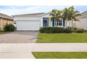 White one-story house with a two-car garage and landscaped lawn at 6308 Chirpine Ln, St Cloud, FL 34771