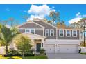 Two-story home with gray siding, white trim, and a three-car garage at 11120 Robert Frost Dr, Winter Garden, FL 34787