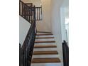 Wooden staircase with black railings leading to the upper level at 1424 Sophie Way, Kissimmee, FL 34744