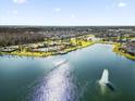 Expansive aerial view of homes surrounding lake with fountain and community pool at 2525 Annacella Ave, Kissimmee, FL 34741