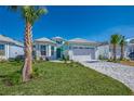 Beautiful single-Gathering home featuring tropical landscaping and a brick paved driveway at 306 Hang Loose Way, Daytona Beach, FL 32124