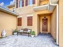 Charming front courtyard with pavers, seating and covered entrance with stylish front door at 3841 Golden Knot Dr, Kissimmee, FL 34746