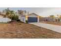 Single-story house with a navy blue garage door and well-manicured lawn at 386 Marion Oaks Trl, Ocala, FL 34473