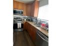 Galley kitchen with wood cabinets, granite counters, and stainless steel appliances at 428 Sand Lime Rd, Winter Garden, FL 34787