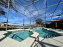 Screened-in pool and spa area with a view of a lake and community at 4525 Stella St, Kissimmee, FL 34746