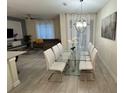 Elegant dining room with a glass-top table and comfortable white chairs, perfect for entertaining guests at 4976 Windermere Ave, Kissimmee, FL 34746