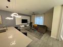 Open-concept living room featuring a modern entertainment center and a comfortable sectional sofa at 4976 Windermere Ave, Kissimmee, FL 34746