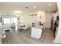 Open floor plan with modern kitchen, dining area, and living room featuring hardwood floors at 697 Stoney Point Cir, Davenport, FL 33896