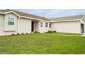 A well manicured lawn and garden beds lead to the front entrance of this single story home at 827 Albi Ct, Kissimmee, FL 34759