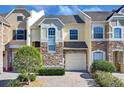 Two-story townhouse with stone facade and a paved driveway at 1009 Wood Cv, Kissimmee, FL 34743