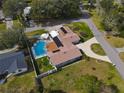 Aerial view of a home featuring a private backyard pool, lush landscaping, and a circular driveway at 123 Lakeview Dr, Auburndale, FL 33823
