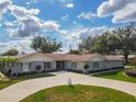 Charming one-story home featuring a circular driveway, lush landscaping, and a well-maintained lawn at 123 Lakeview Dr, Auburndale, FL 33823