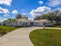 Stunning single-story home showcasing a circular driveway and beautiful landscaping at 123 Lakeview Dr, Auburndale, FL 33823
