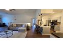 Open-concept living room and kitchen with hardwood floors, modern decor, and bar-style seating at the kitchen counter at 14214 Fredricksburg Dr # 106, Orlando, FL 32837