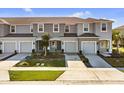 Aerial view of three-unit townhouse building with gray siding and attached garages at 2106 Crystal Bell St, Orlando, FL 32824