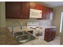 Kitchen featuring a double sink, white appliances, and plenty of cabinet space at 261 Autumn Ln # 4, Kissimmee, FL 34743