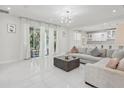 Bright living room with sliding glass doors, leading to a patio, and a modern sofa at 3209 Eagle Watch Dr, Kissimmee, FL 34746