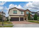 Two-story house with stone accents and a two-car garage at 3240 Preserve Dr, Orlando, FL 32824